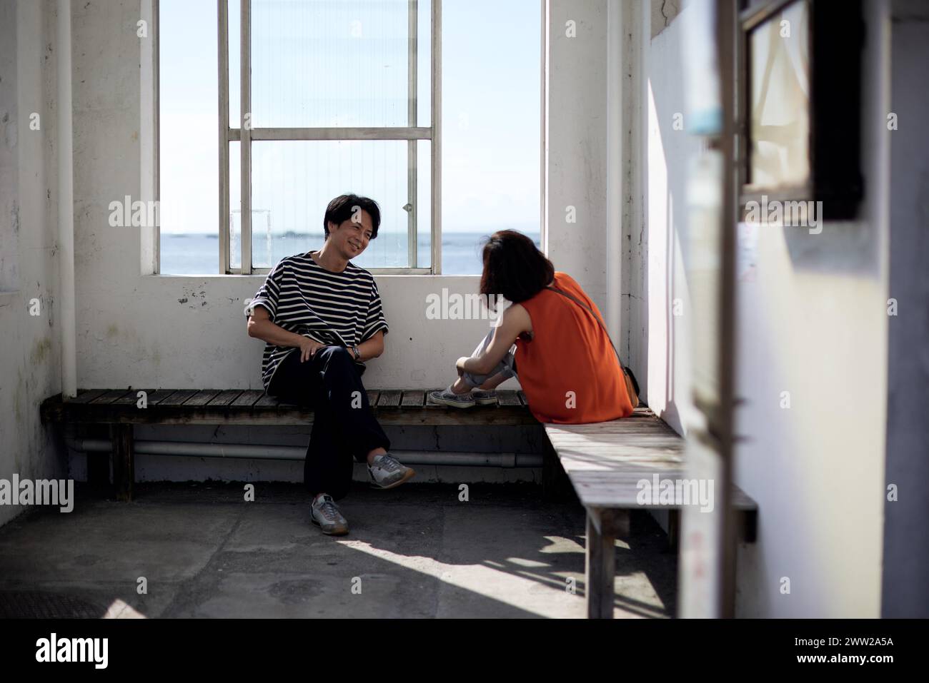 Un giovane seduto su un banco di lavoro Foto Stock