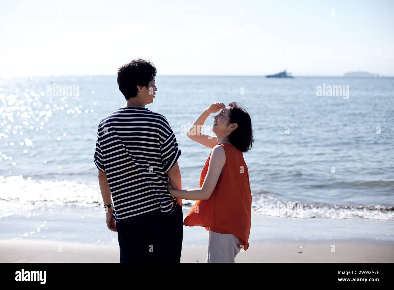 Un uomo e una donna in piedi sulla spiaggia Foto Stock
