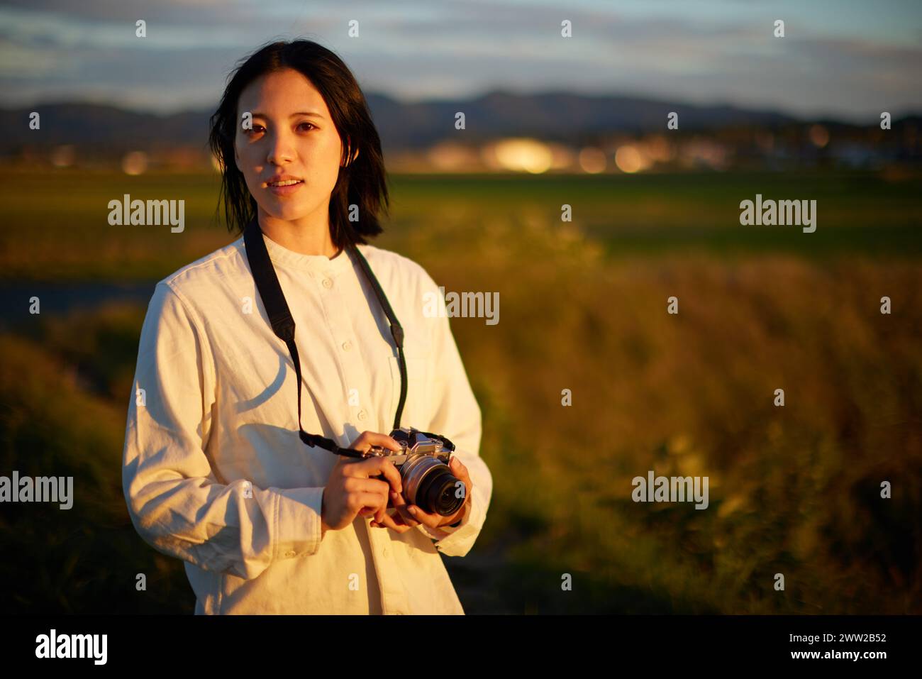 Una donna che tiene una macchina fotografica in un campo Foto Stock