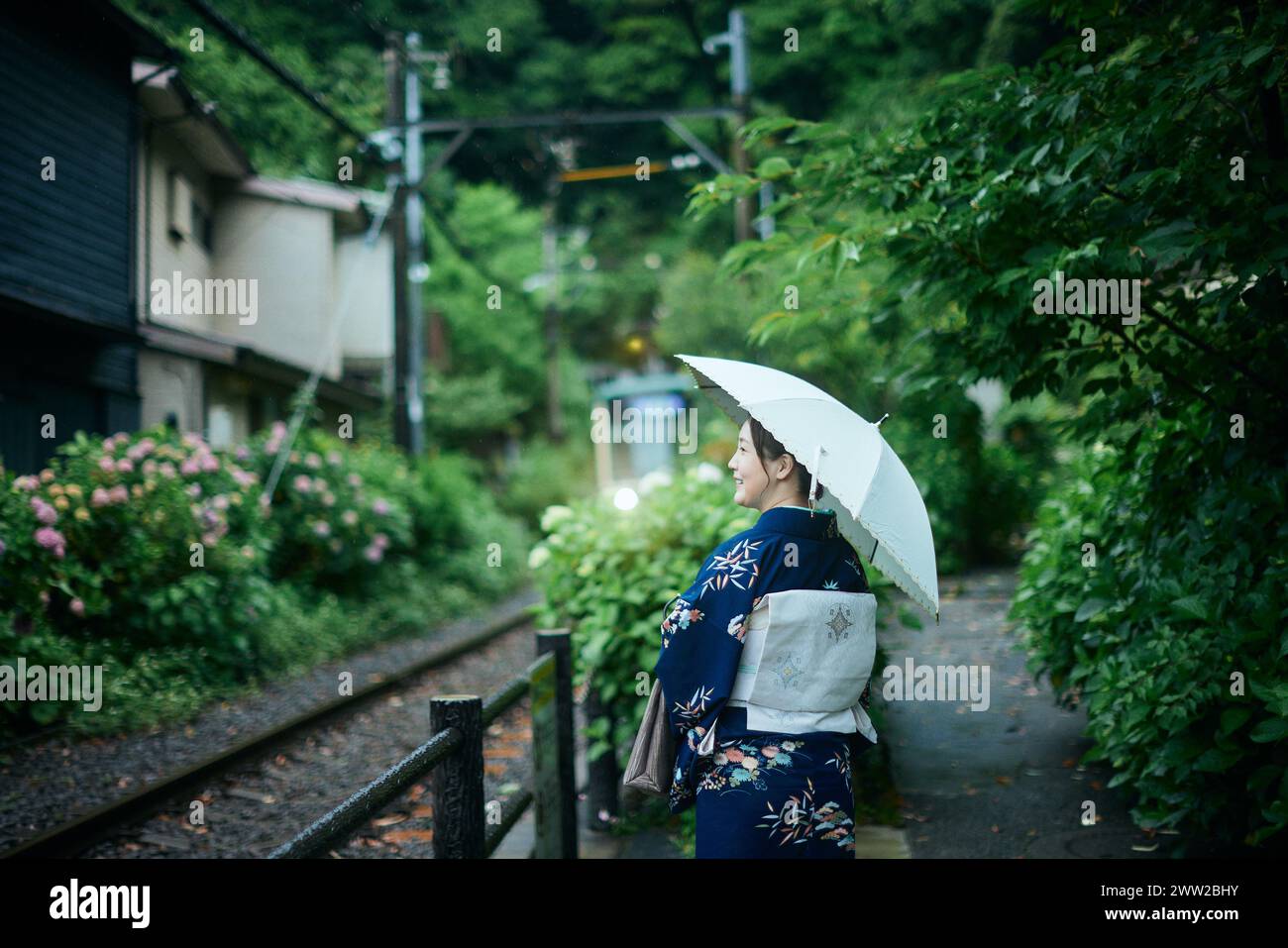 Una donna in un kimono con un ombrello Foto Stock