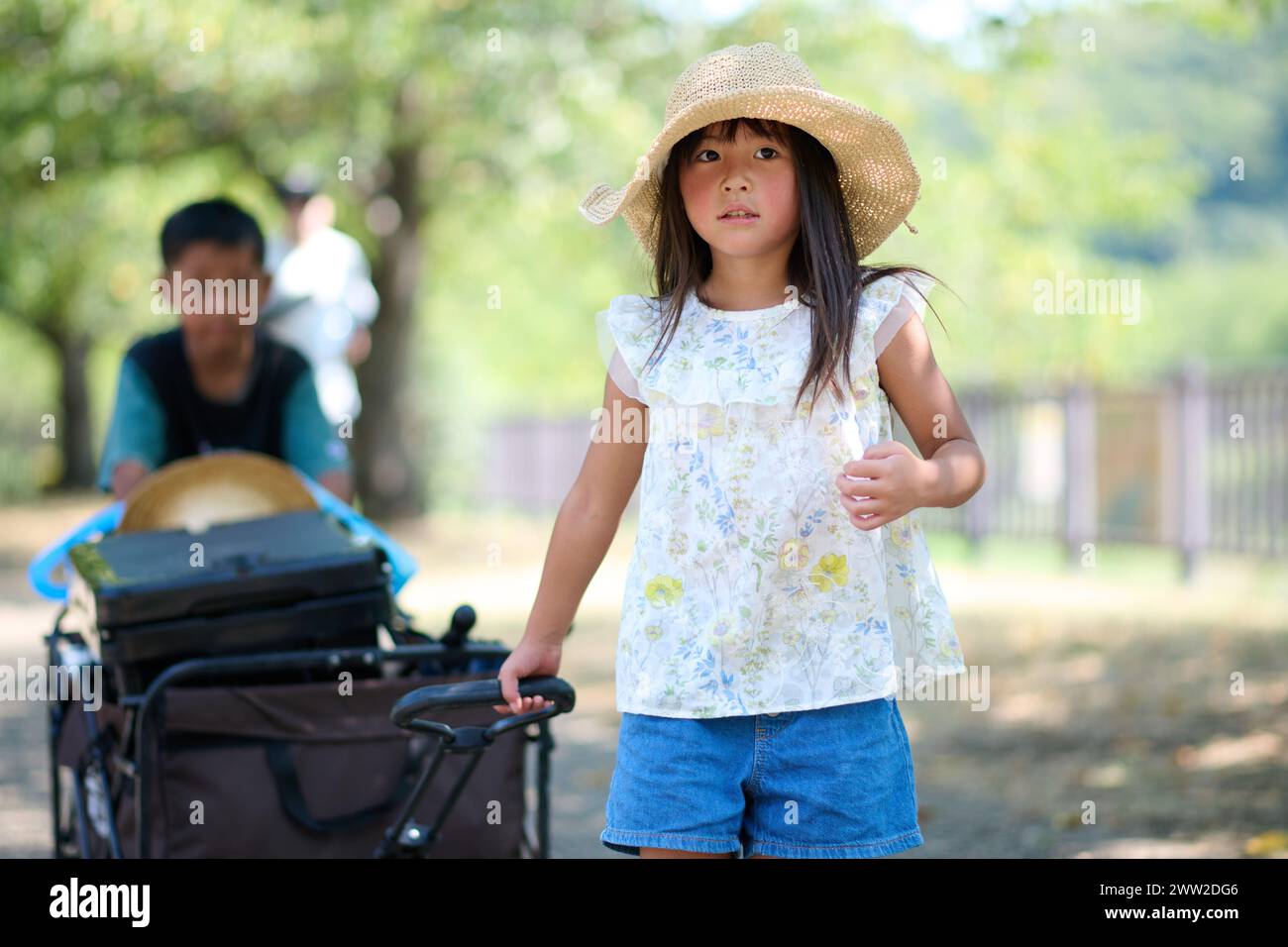 Una bambina con un cappello e un carro Foto Stock