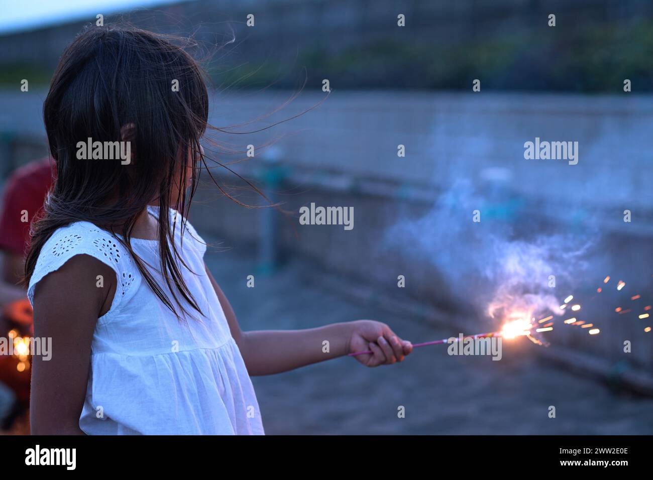 Una bambina che tiene in mano uno sparkler Foto Stock