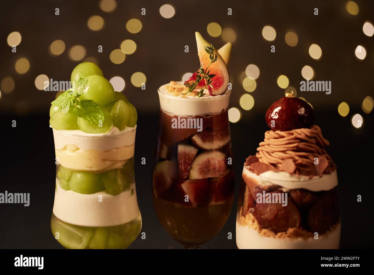 Tre diversi dessert in bicchieri su sfondo scuro Foto Stock