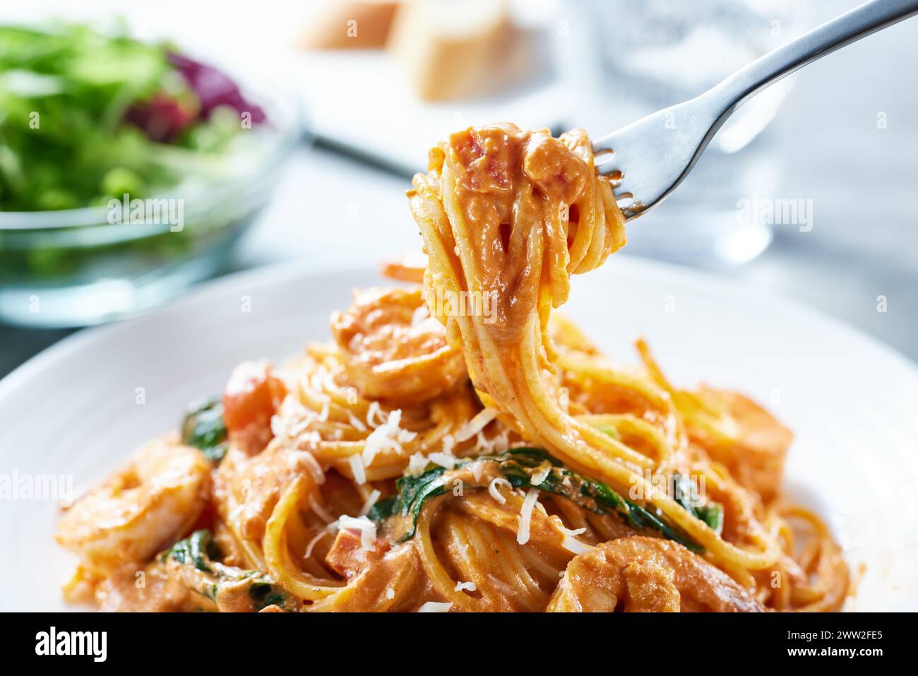 Un piatto di spaghetti con gamberi e spinaci Foto Stock