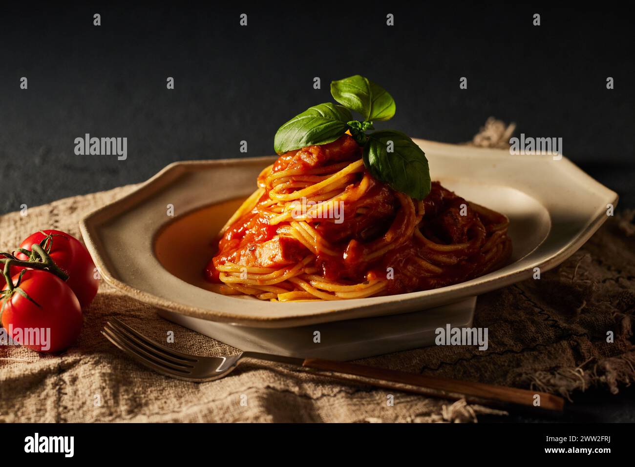 Spaghetti con salsa di pomodoro e foglie di basilico su un piatto Foto Stock