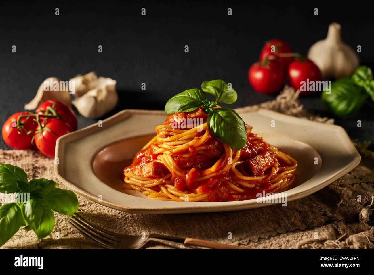 Spaghetti con salsa di pomodoro e foglie di basilico su un piatto Foto Stock
