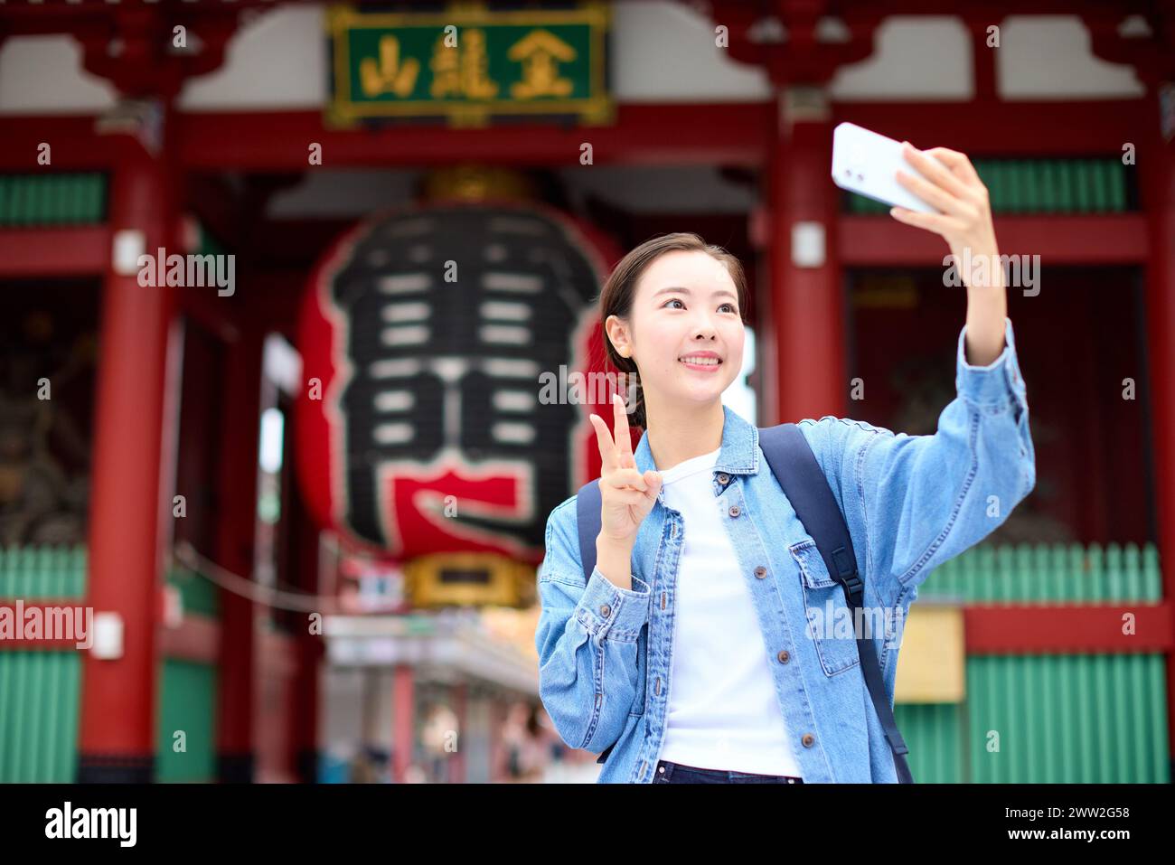 Una donna che fa un selfie davanti a un tempio Foto Stock