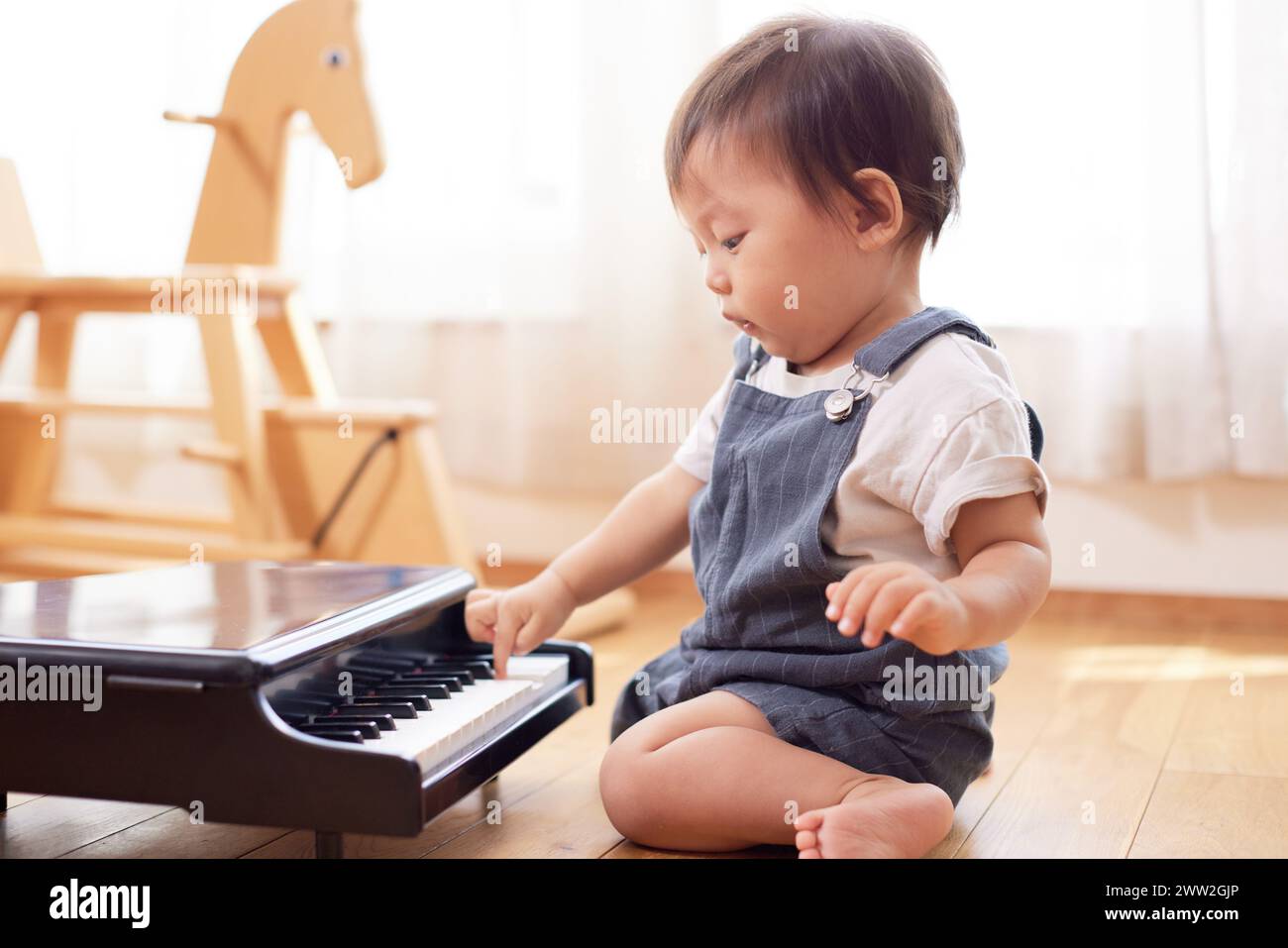 Un bambino che suona con un pianoforte Foto Stock