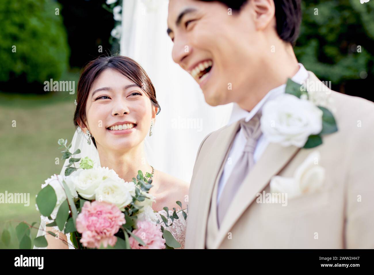Una coppia appena sposata in piedi sotto un arco nuziale Foto Stock