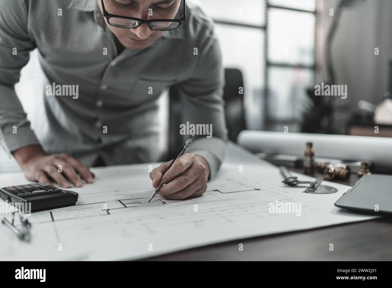 Progettazione che lavora con l'ispezione e il calcolo dei disegni, il righello a triangolo, gli occhiali di sicurezza, la bussola, il calibro a corsoio su Blueprint. Ingegnere, architetto Foto Stock