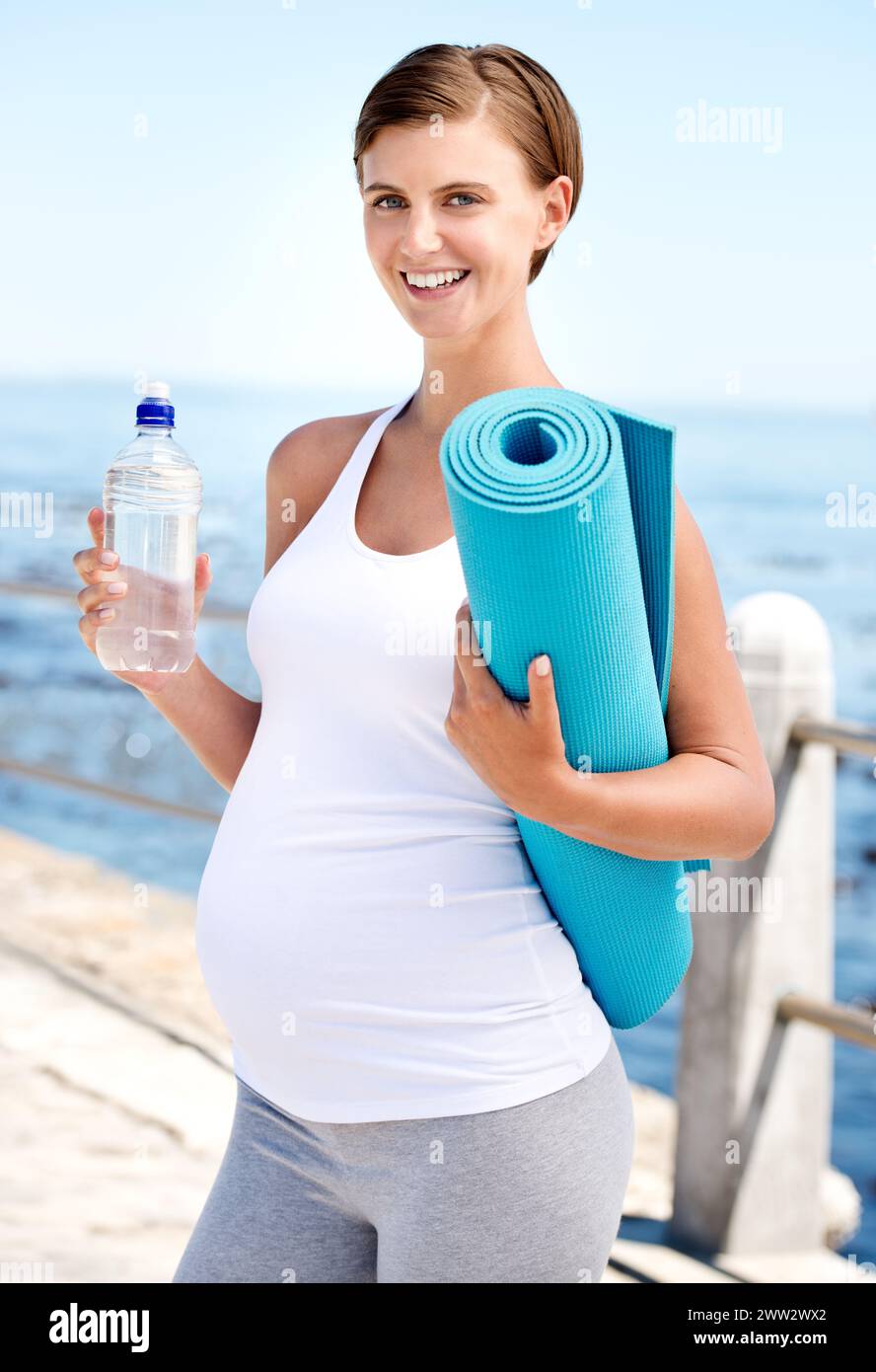 Donna incinta, acqua e yoga all'aperto in spiaggia con salute prenatale, fitness in natura con h2o e oceano. Nutrizione, pilates di gravidanza e liquidi Foto Stock