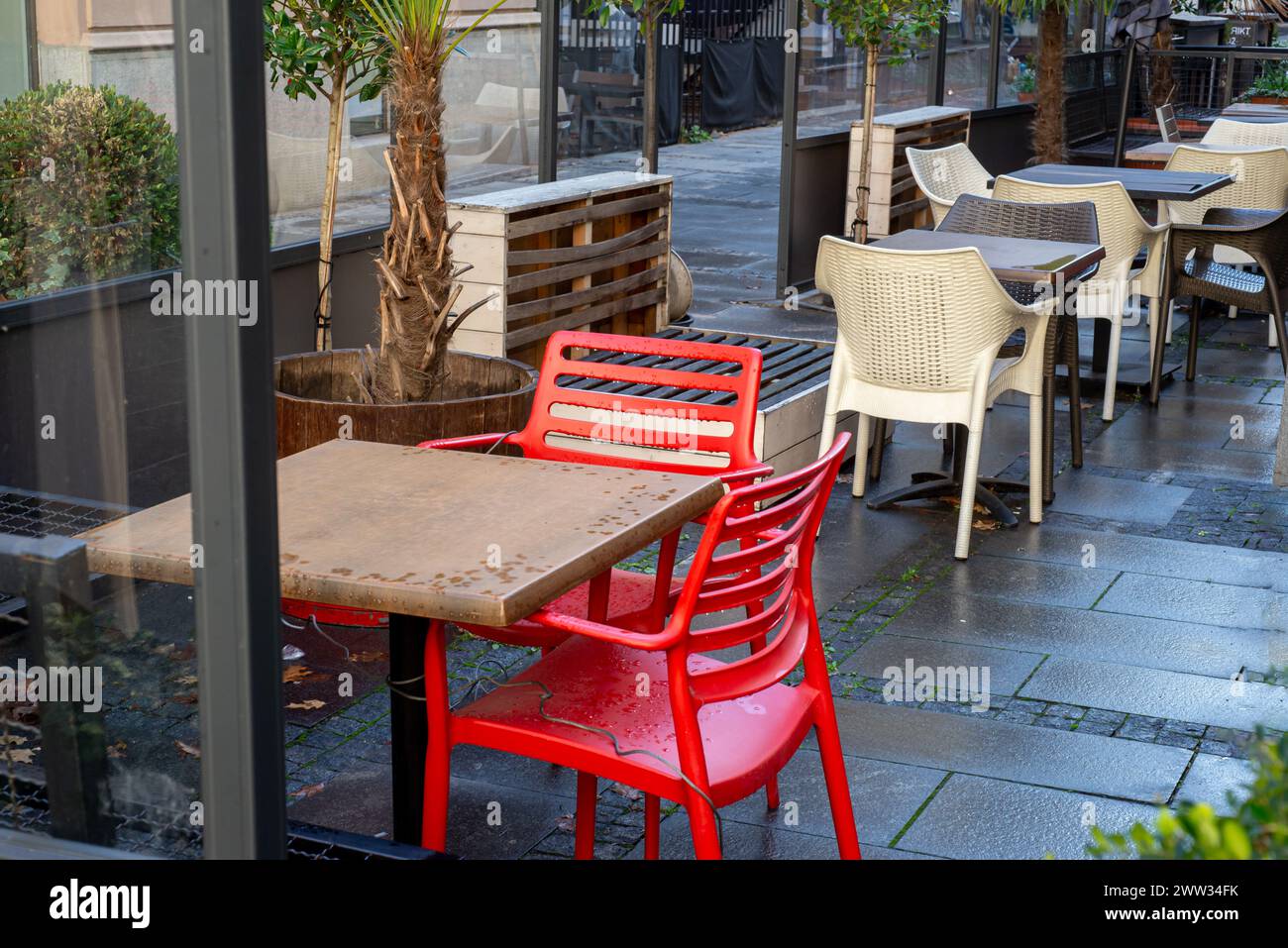 Sedie rosse e bianche nel ristorante dopo la pioggia diagonalmente nella cornice Foto Stock