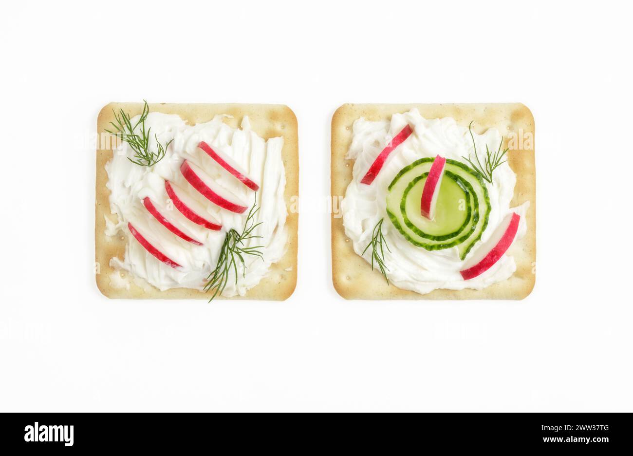 Due cracker quadrati con crema di formaggio spalmabile, ravanello, aneto e cetrioli Foto Stock