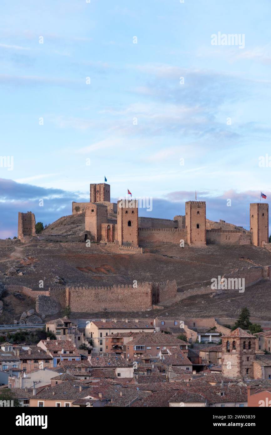 il castello storico si affaccia su una pittoresca cittadina, che mostra il contrasto architettonico e il passare del tempo Foto Stock