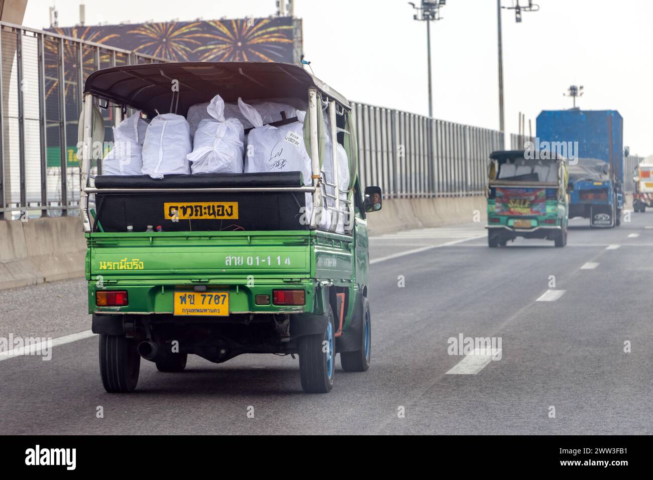 BANGKOK, THAILANDIA, 26 2024 FEB, Un piccolo camion pieno di sacchi guida lungo l'autostrada Foto Stock