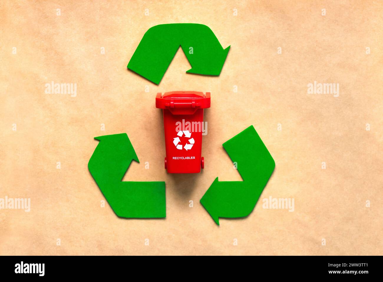 Vista dall'alto del simbolo di riciclaggio con cestino rosso su sfondo di carta riciclata. Concetto di riciclaggio ecologico Foto Stock