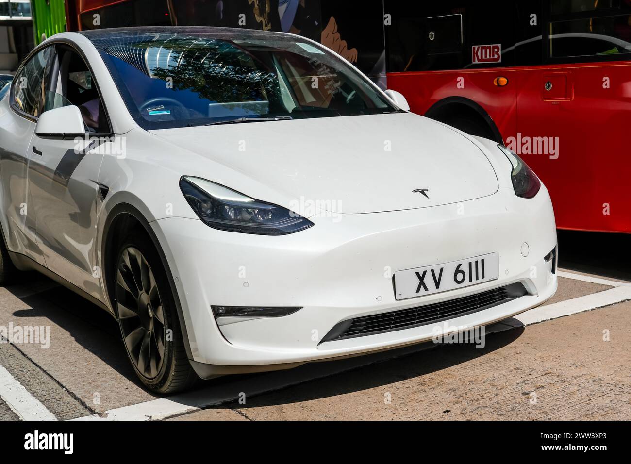 Modello di auto Tesla bianca che guida sulla strada cittadina. Cina, Hong Kong, 19 gennaio 2024. Foto Stock