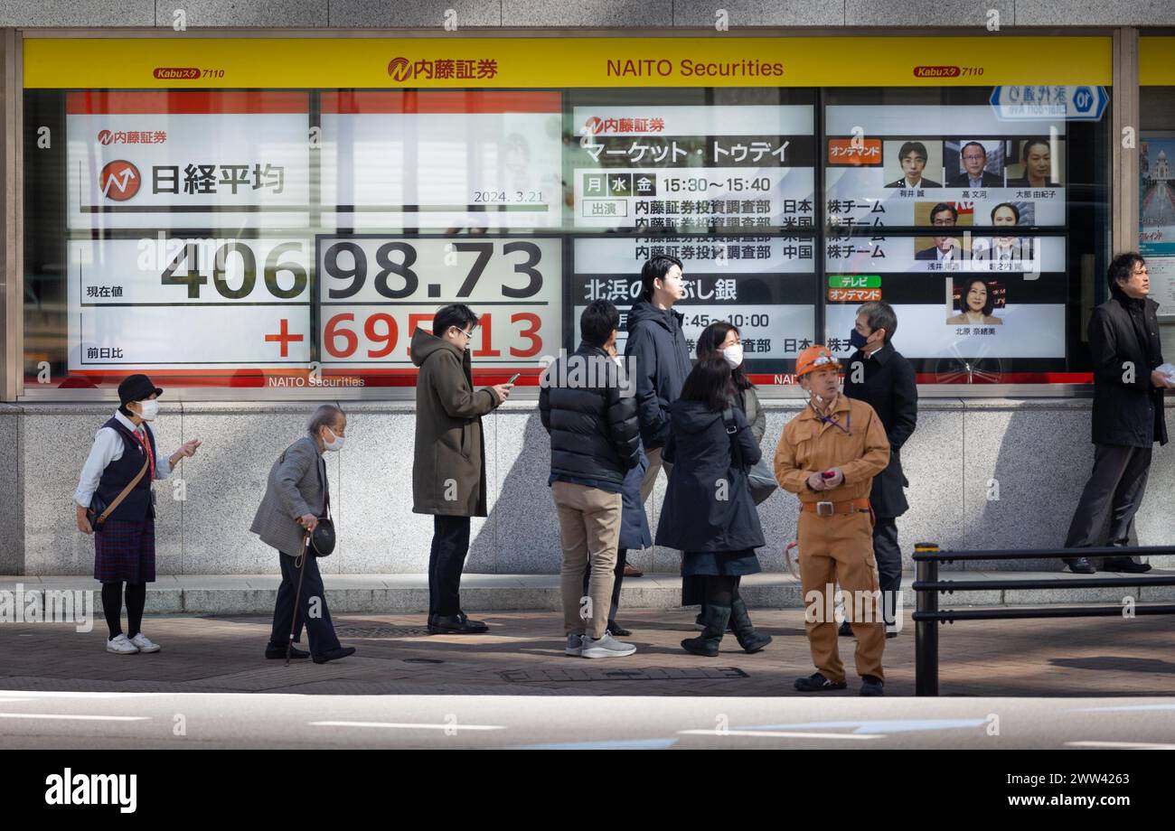 Tokyo, Giappone. 21 marzo 2024. I membri del pubblico passeranno davanti all'esposizione che mostra la media delle azioni Nikkei nel quartiere finanziario di Tokyo. Crediti: Marcin Nowak/Alamy Live News Foto Stock