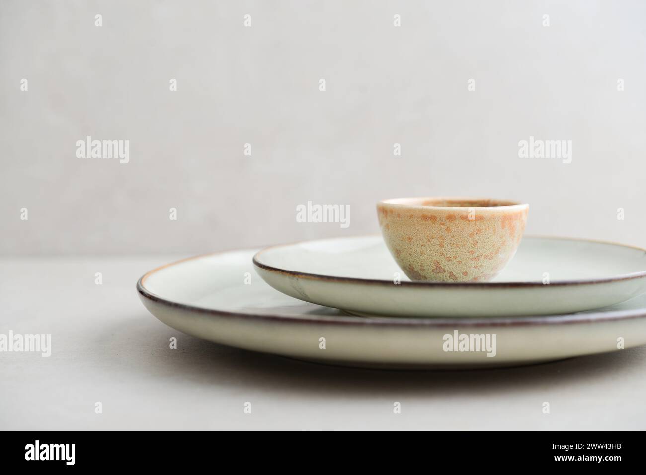 Due piatti di diverse dimensioni e una piccola ciotola su sfondo chiaro Foto Stock