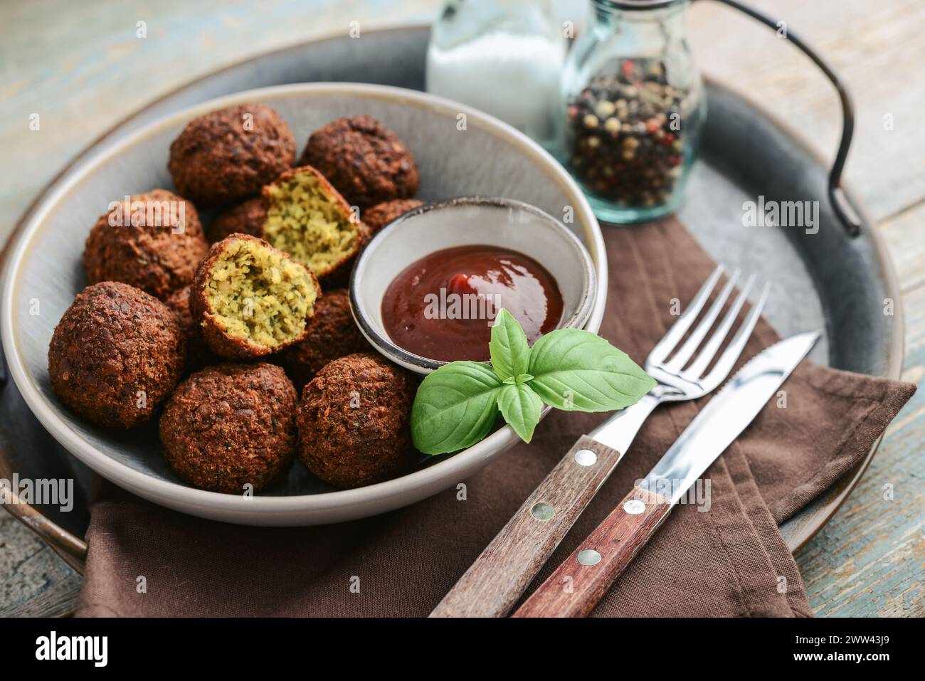 Piatto di falafel con spezie e zuppa su vassoio di metallo su fondo di legno, primo piano Foto Stock