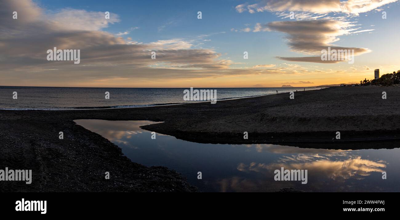 Atardecer en la playa de Estepona que ofrece un escenario de serenidad y belleza costera. España Foto Stock