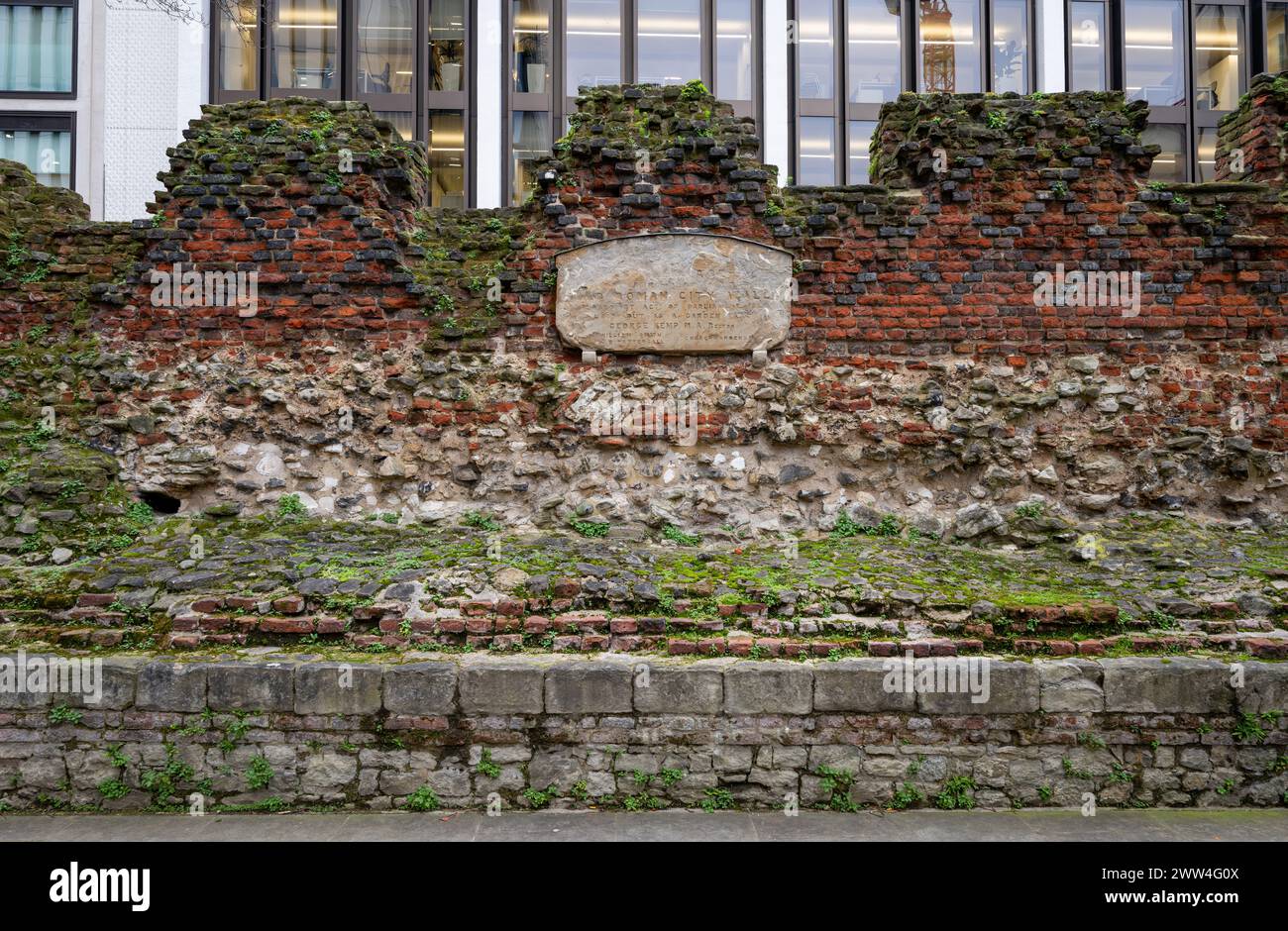 Parte dell'antica cinta muraria di Londra, Regno Unito. Un muro medievale con le mura romane alla base e sormontato da un parapetto in mattoni aggiunto nel 1477 Foto Stock