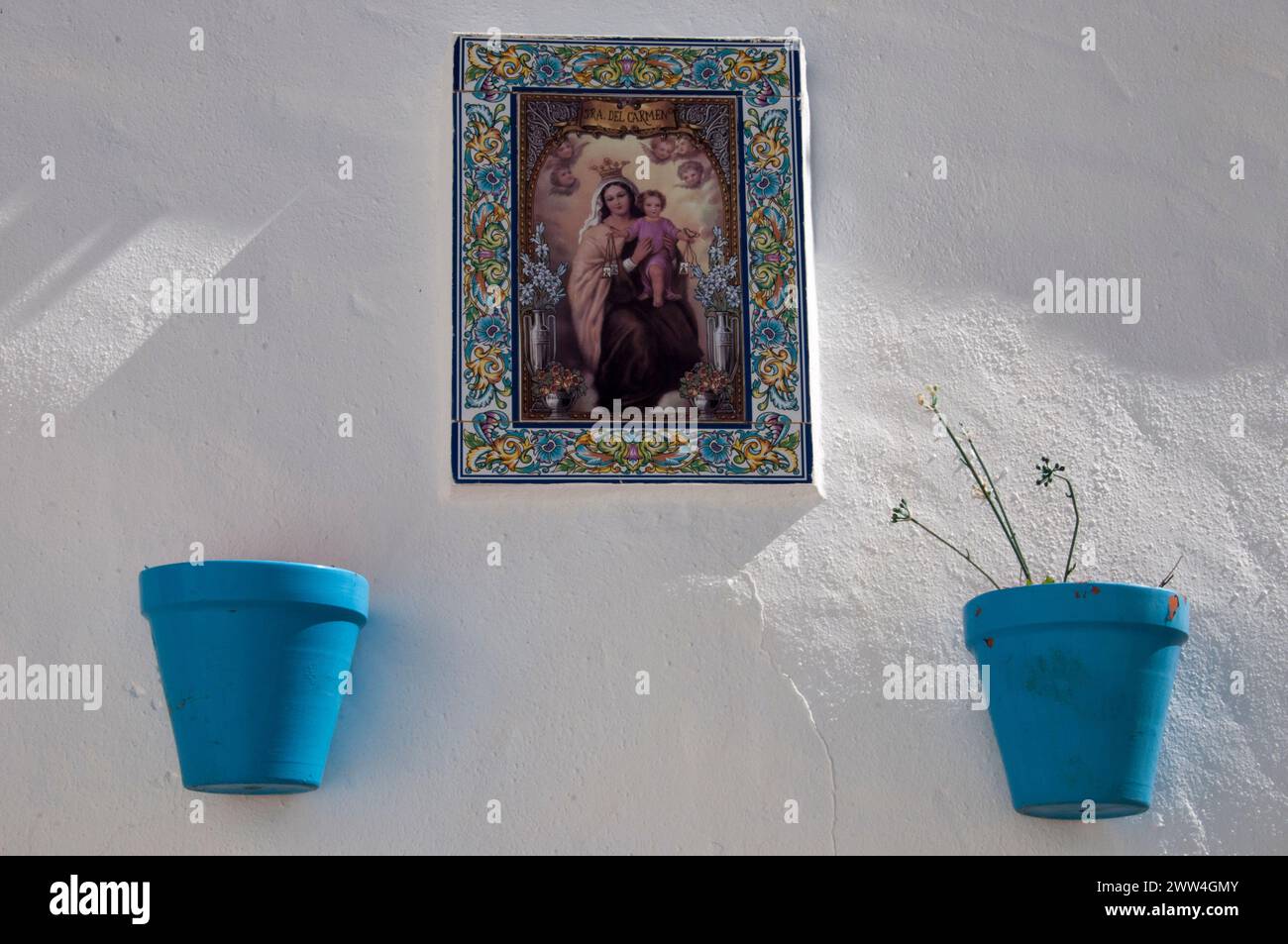 Immagine della Vergine Maria esposta su un muro imbiancato a Frigiliana, uno dei più acclamati villaggi bianchi dell'Andalusia, nel sud della Spagna Foto Stock