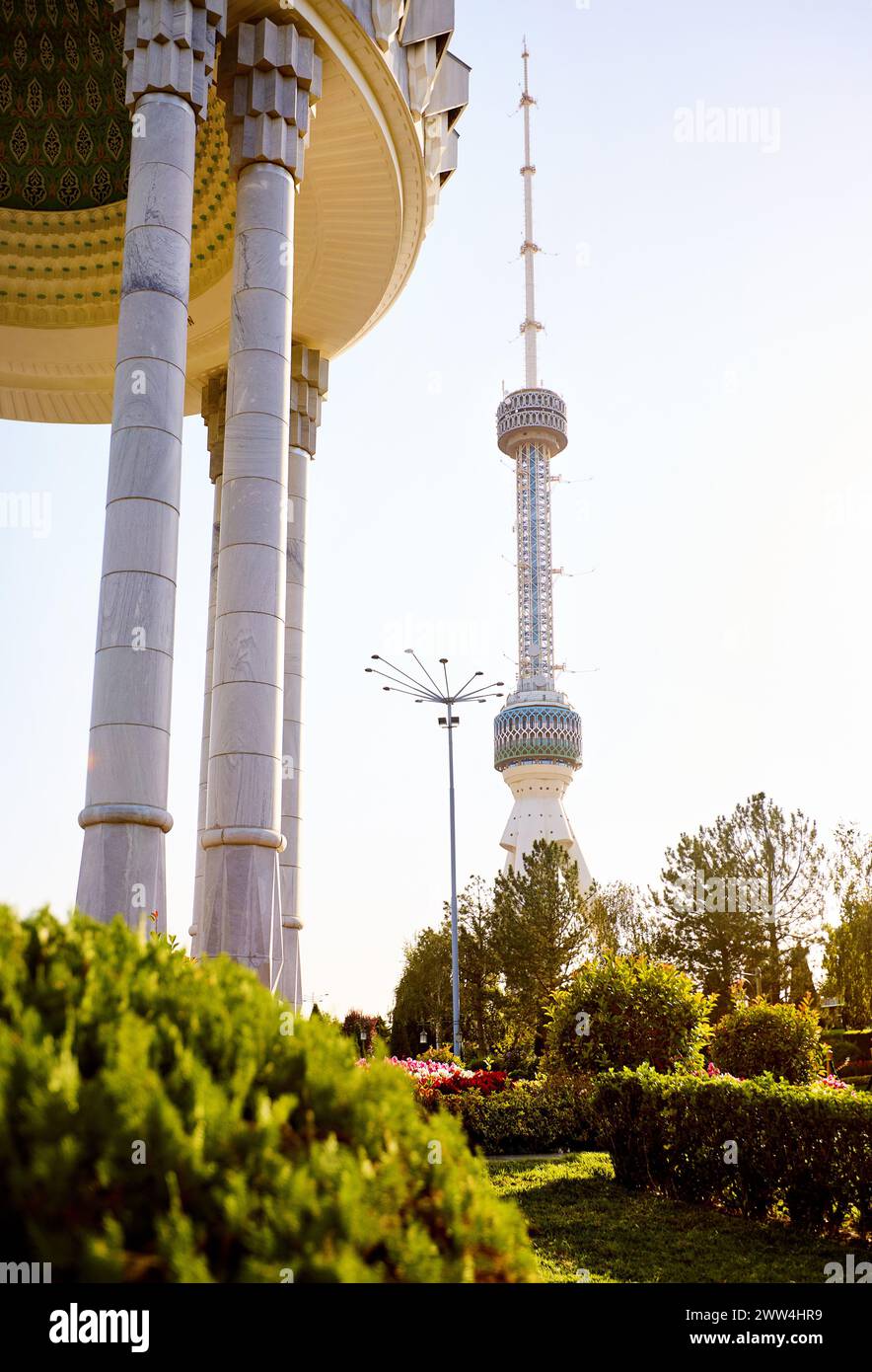 La torre della televisione di Tashkent Toshkent Teleminorasi e la colonna commemorativa nel parco al tramonto in Uzbekistan Foto Stock