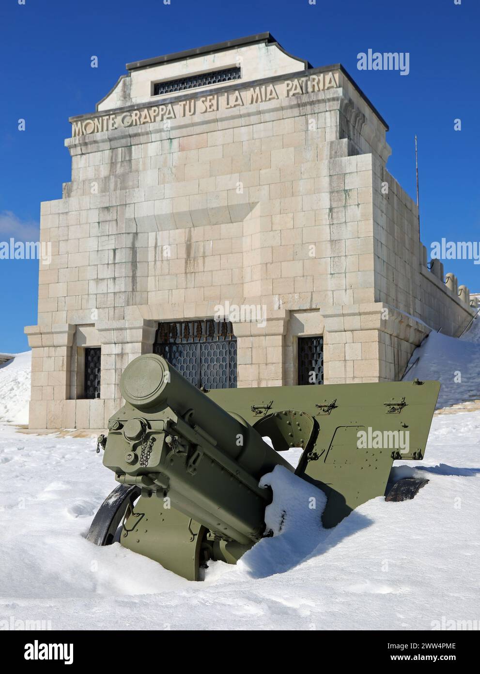 Pieve, TV, Italia - 13 marzo 2024: Memoriale militare di guerra con cannone sulla neve e testo che significa Grappa Monte tu sei la mia patria Foto Stock