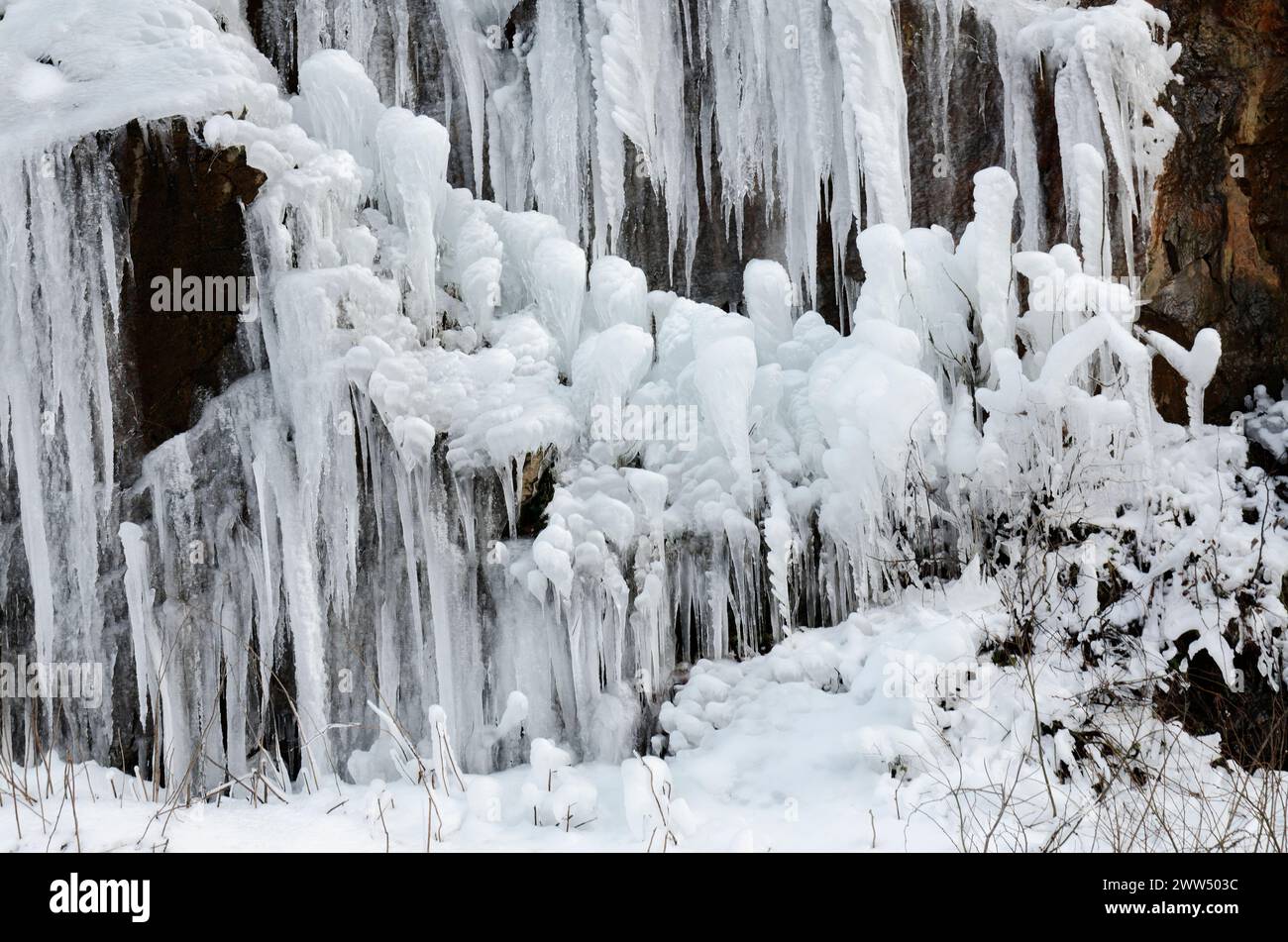 Stalattiti del ghiaccio. Appendere il ghiaccio appuntito, acqua ghiacciata. Sfondo e trame. Inverno. Foto Stock