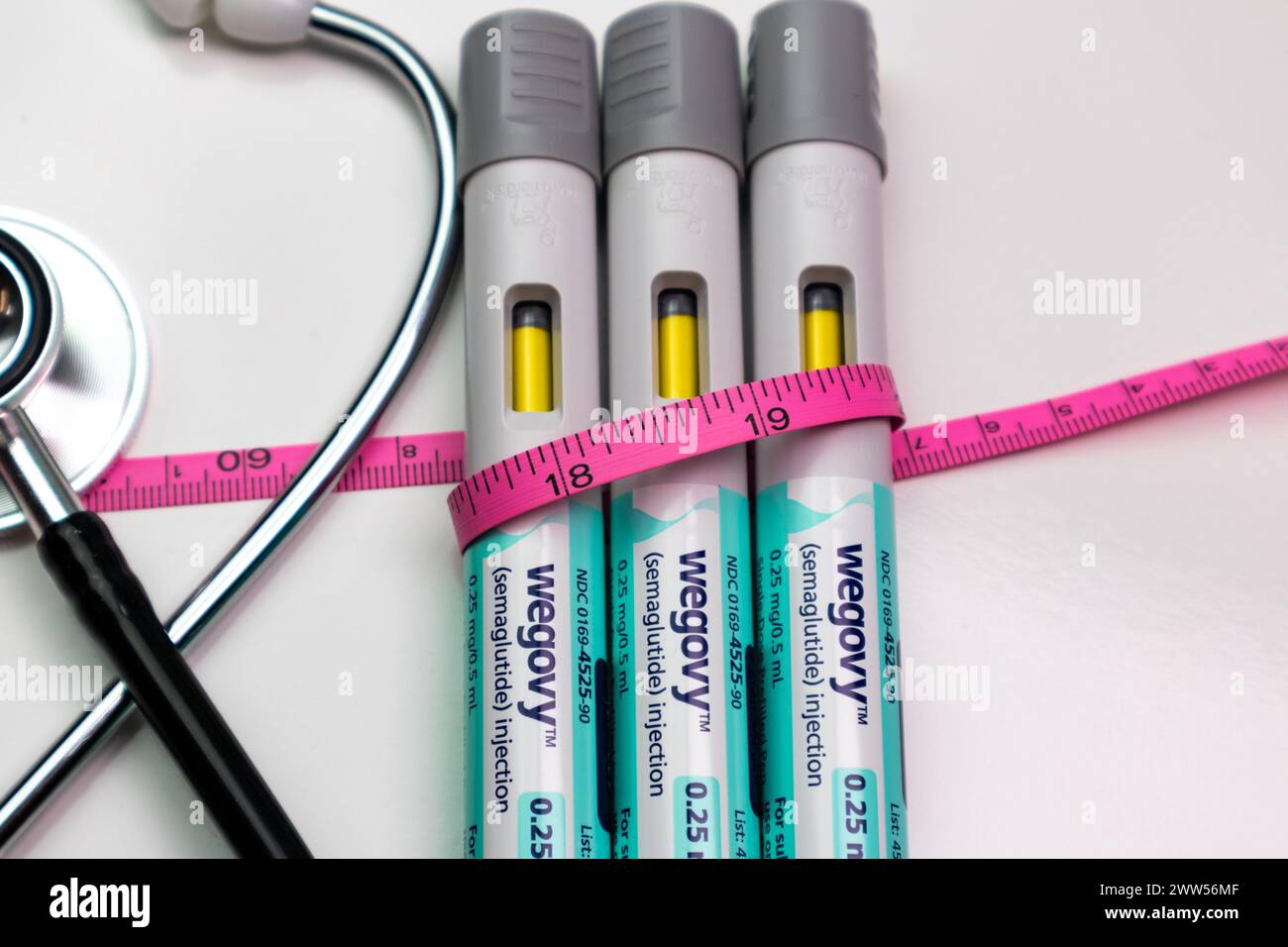 Penne per farmaci per iniettori automatici Wegovy con metro a nastro rosa e stetoscopio Foto Stock