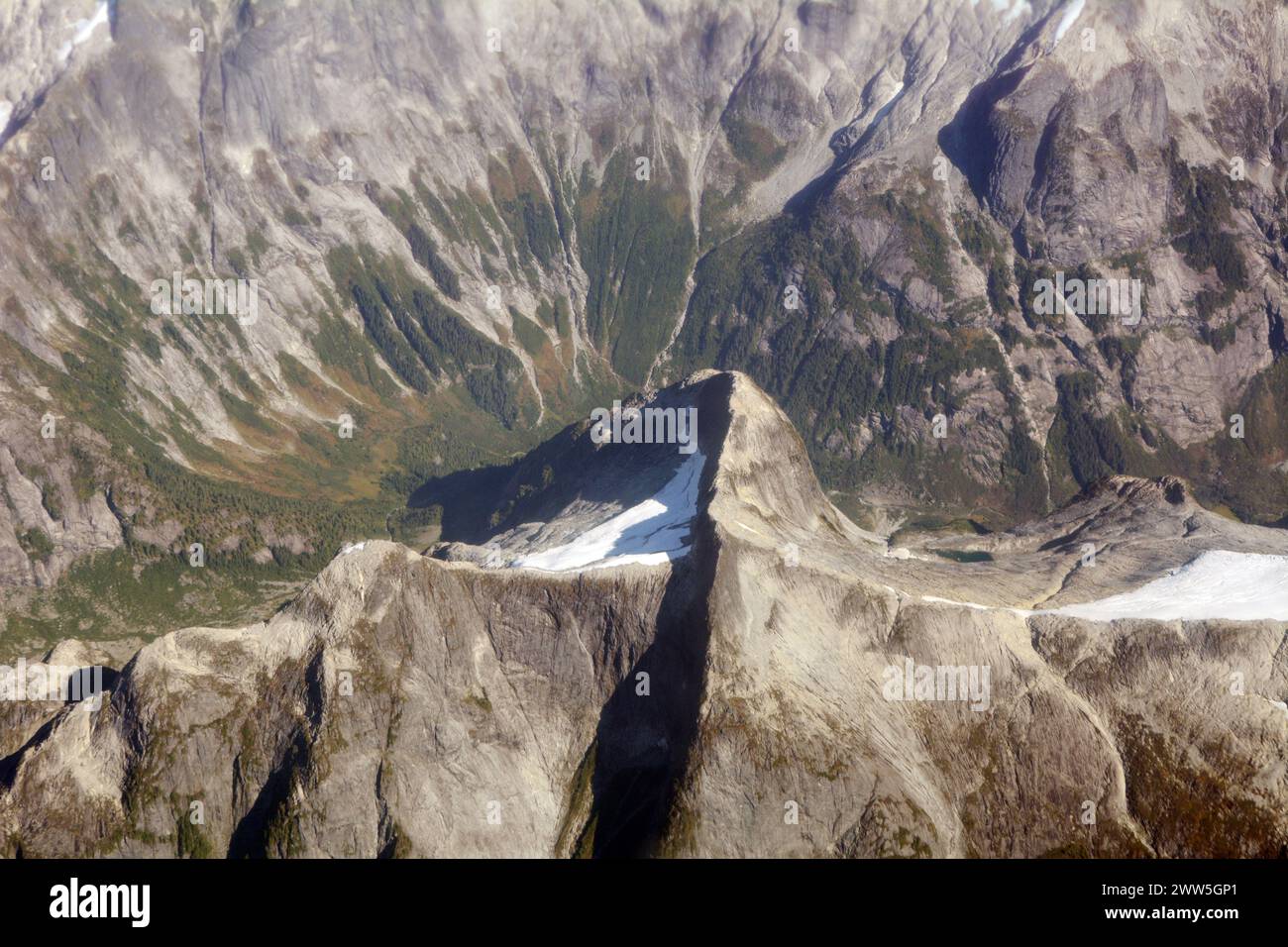 Vista aerea della cima di una montagna e della cresta sopra la testa di una valle alpina nelle montagne costiere, vicino a Bute Inlet, British Columbia, Canada. Foto Stock