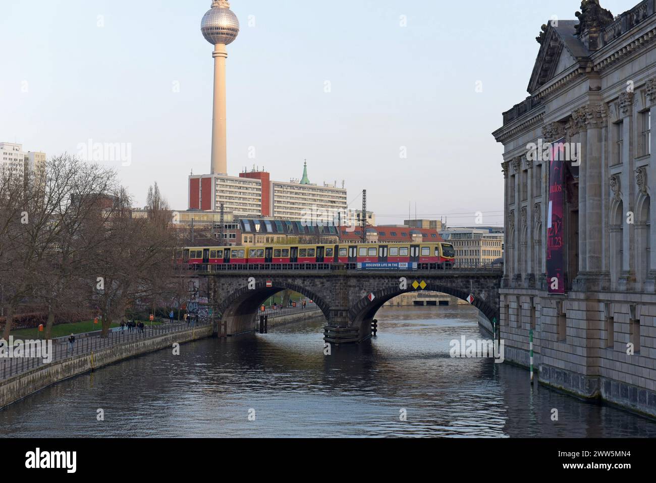 Treno suburbano della S-Bahn di Berlino che attraversa il ponte ferroviario Hackescher Markt, torre della televisione sullo sfondo, Berlino, marzo 2024 Foto Stock