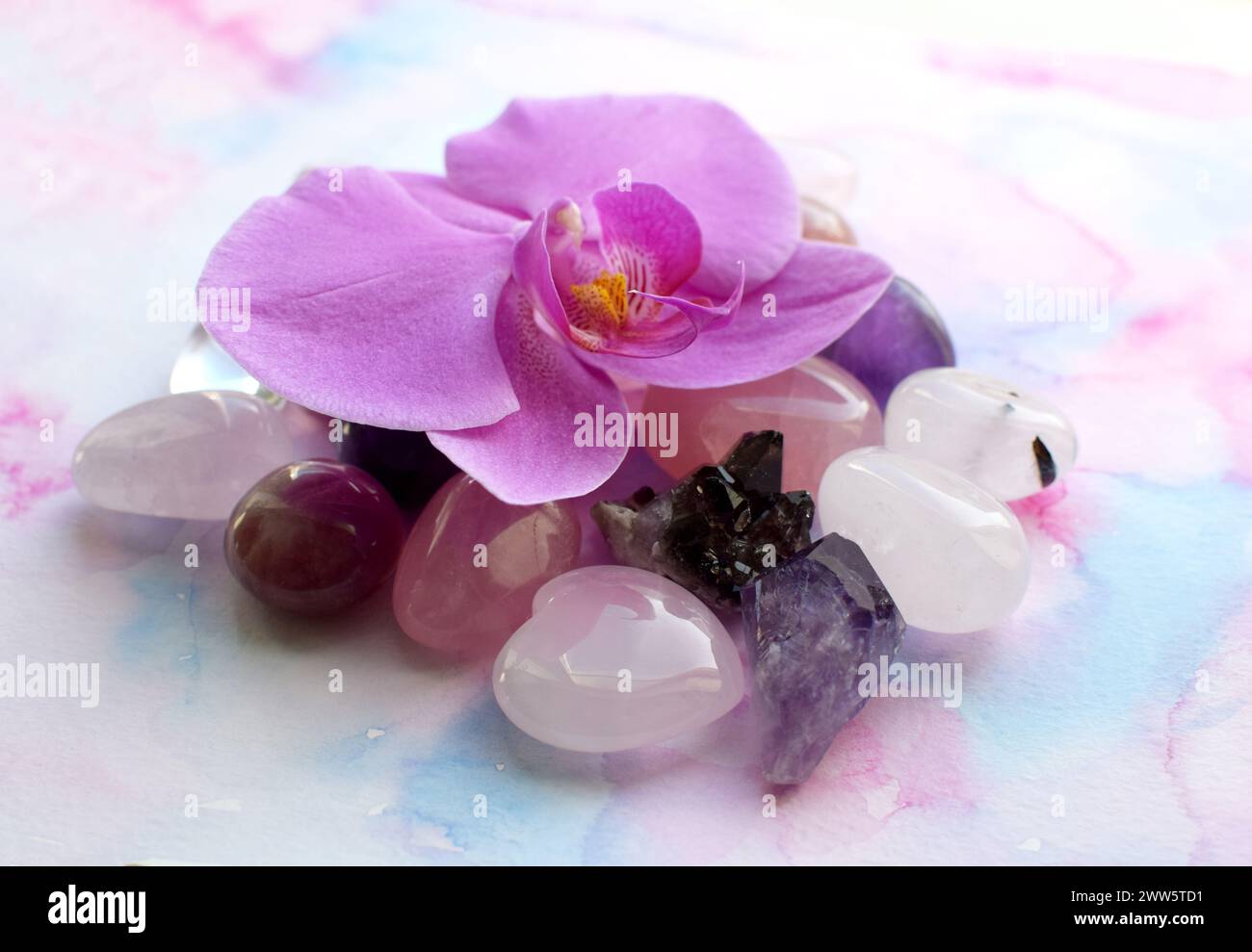 Bellissimi cristalli di ametista e fiori di orchidea. Cristalli curativi, la magia delle pietre preziose. Foto Stock