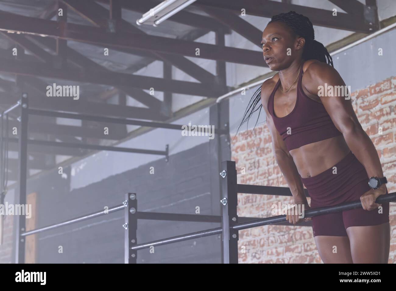 Una donna afroamericana di mezza età forte e in forma sta facendo pull-up con spazio di copia Foto Stock