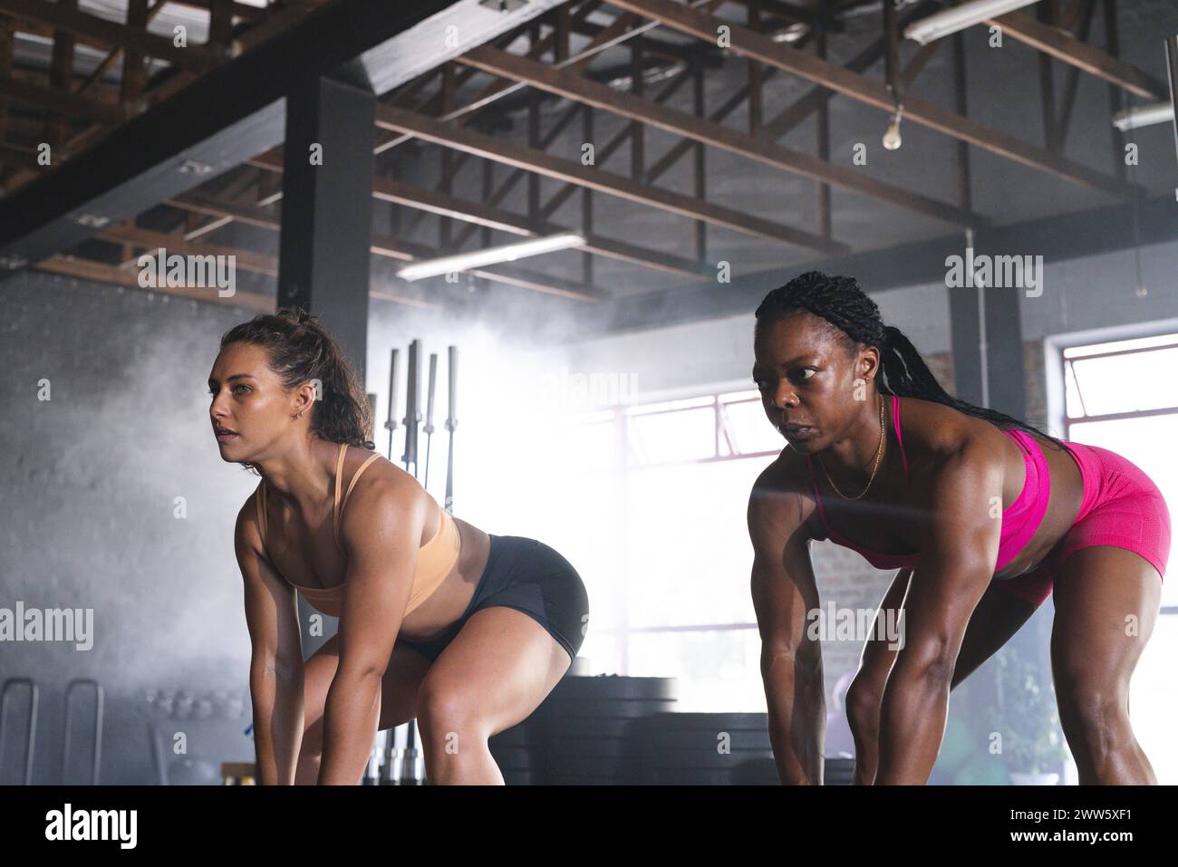 Due donne in forma sono impegnate in un allenamento in palestra Foto Stock