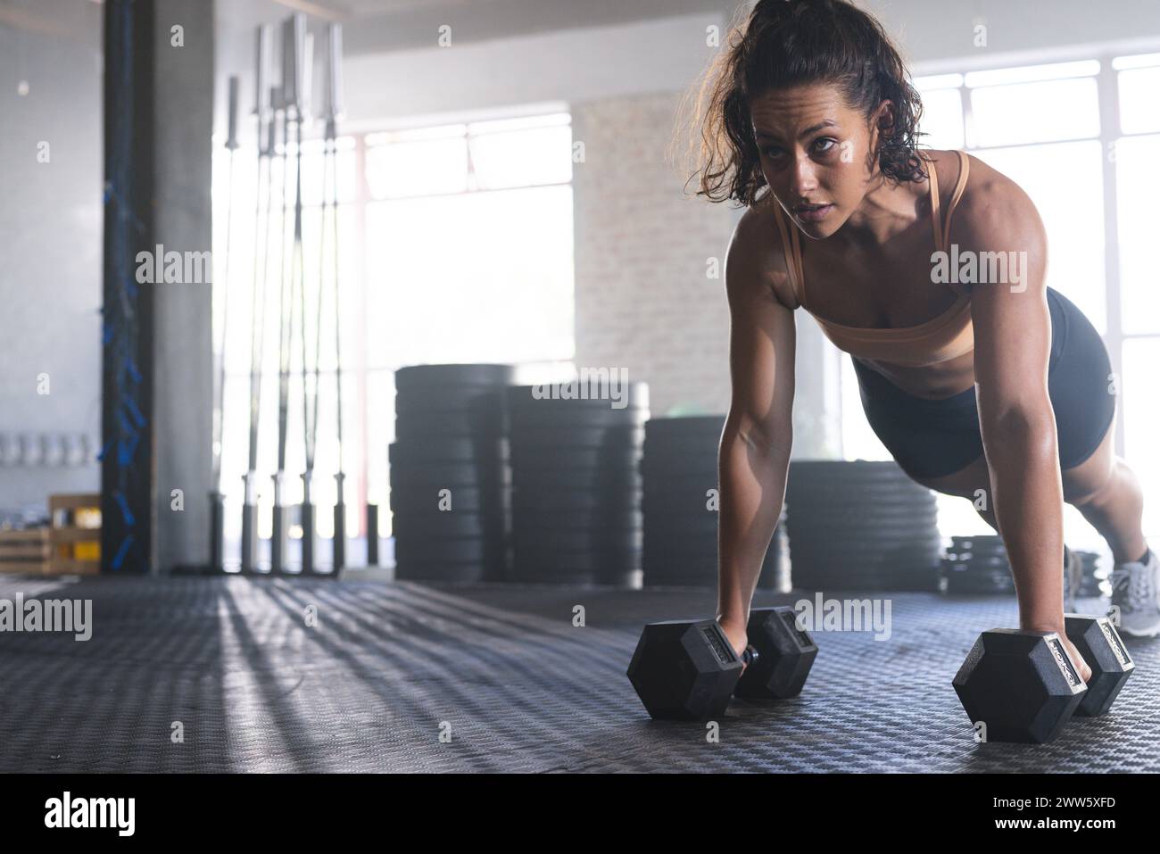 Una giovane donna afroamericana in forma sta facendo un esercizio stupido in palestra con spazio fotocopie Foto Stock