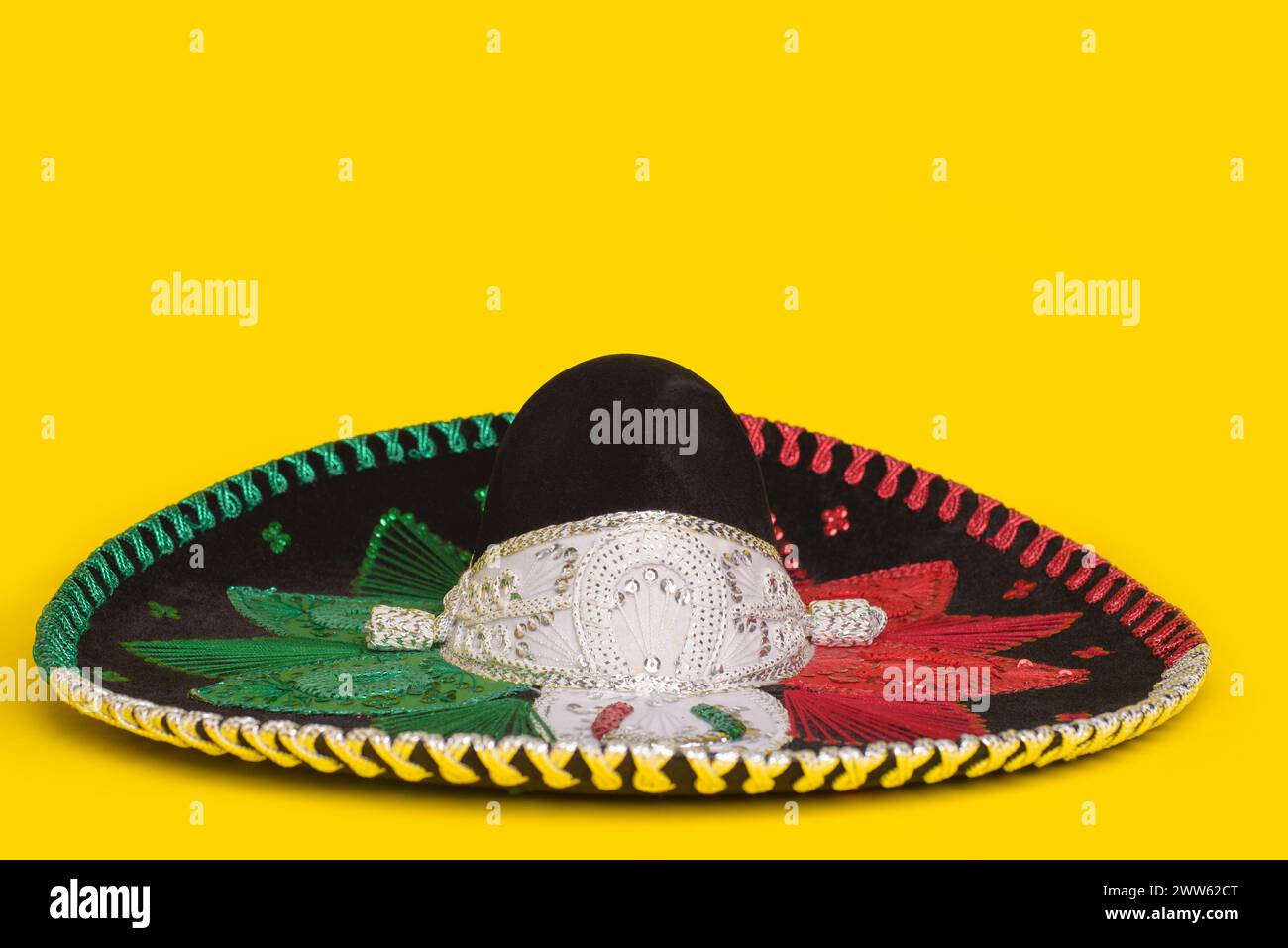 Cappello mariachi tricolore su sfondo giallo. Cinco de mayo, sfondo festivo. Foto Stock