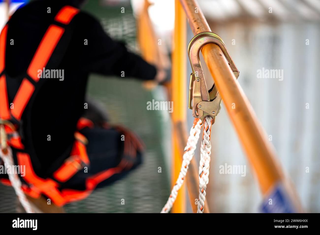 Lavoratori edili che indossano imbracature di sicurezza e linee di sicurezza che lavorano a. alto posto Foto Stock