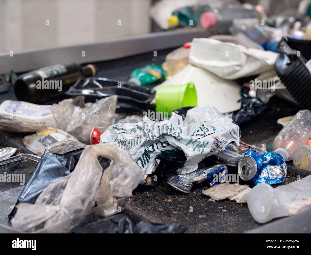 Rifiuti di plastica su un nastro trasportatore in un impianto di gestione dei rifiuti Foto Stock