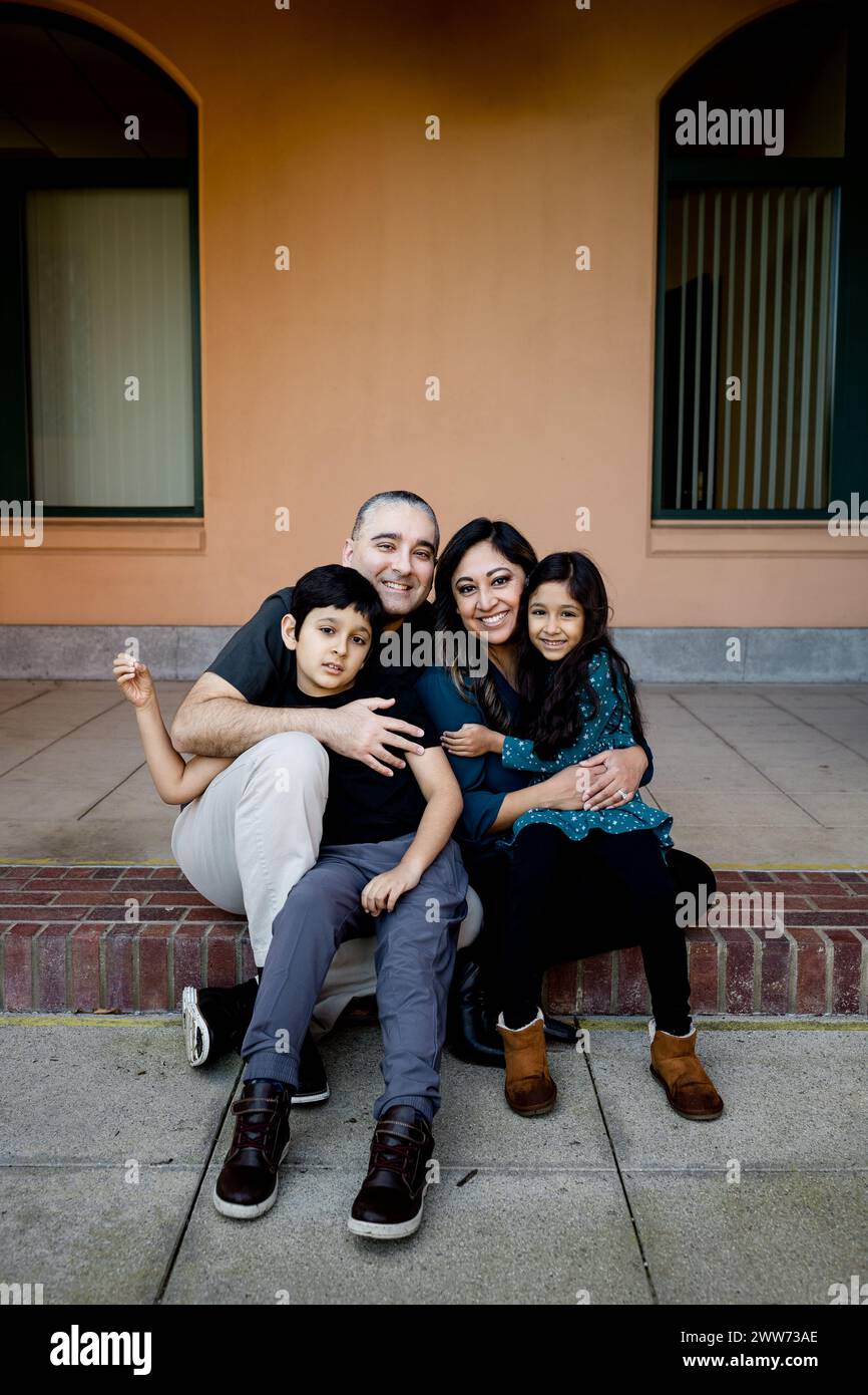 Famiglia di quattro persone che posa per il Ritratto su Brick Step a San Diego Foto Stock