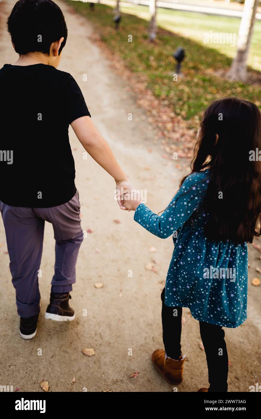 Il fratello autistico tiene la mano con la sorella a Park a San Diego Foto Stock