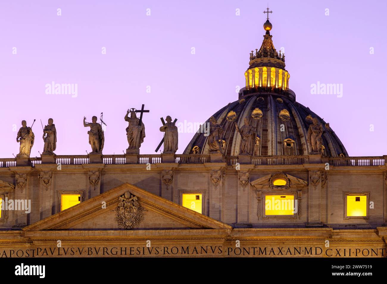 Dettagli: st sul tetto della Basilica di San Pietro (Cattedrale di San Pietro) della città del Vaticano durante il tramonto, con statue e cupola illuminata. Foto Stock