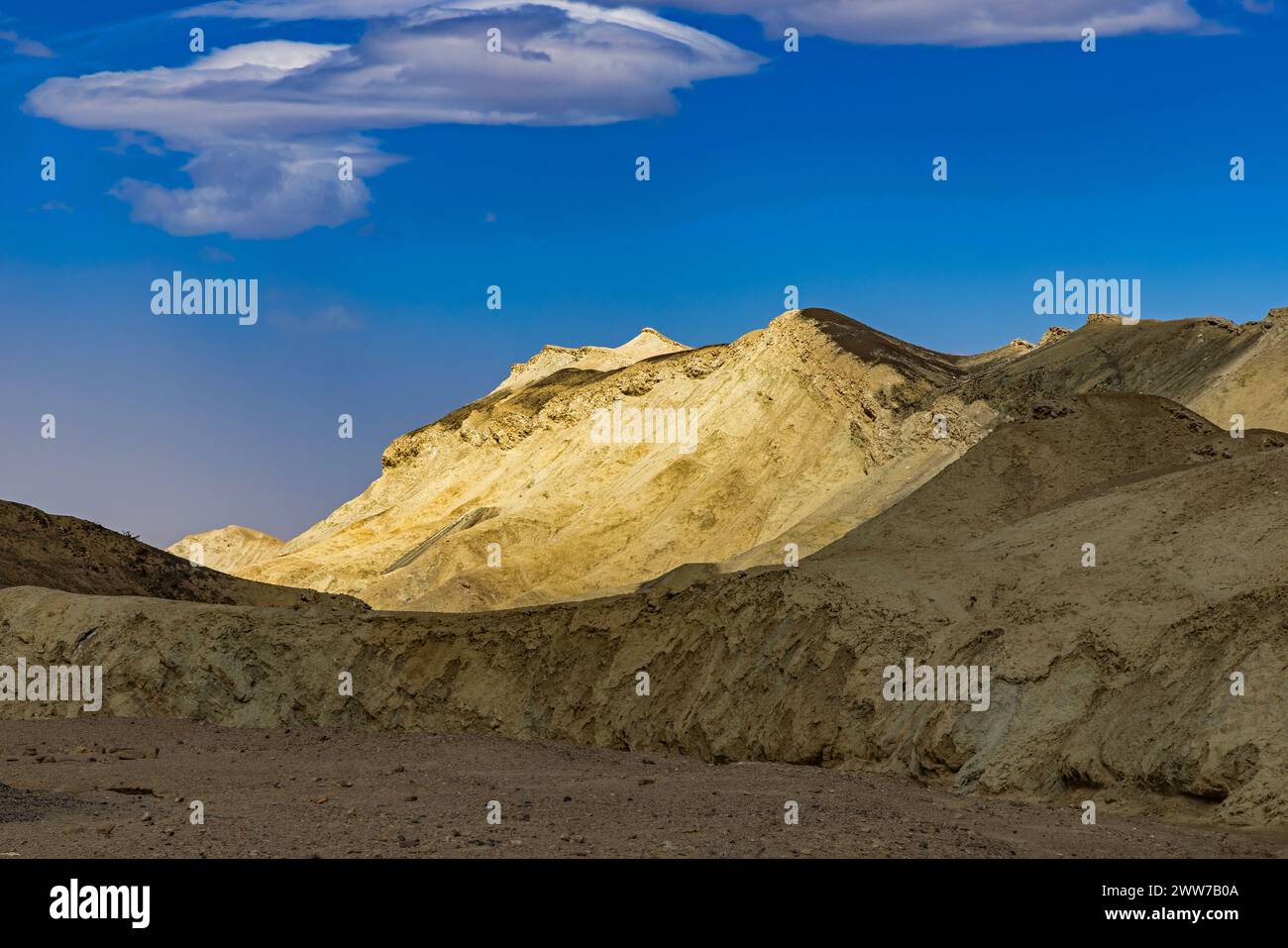 Il sole illumina una montagna dorata vista dalla strada nel 20 Mule Team Canyon nel Death Valley National Park, Inyo County, California, USA. Foto Stock