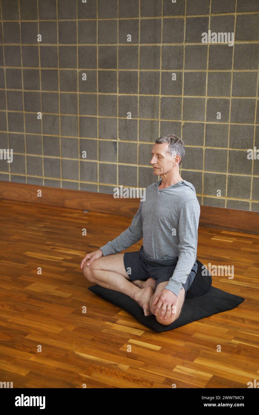 Uomo maturo a praticare Yoga e facile posa Foto Stock