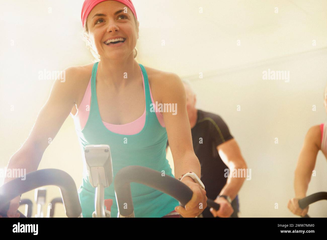 Donna utilizzando l'esercizio bicicletta a lezione di fitness Foto Stock