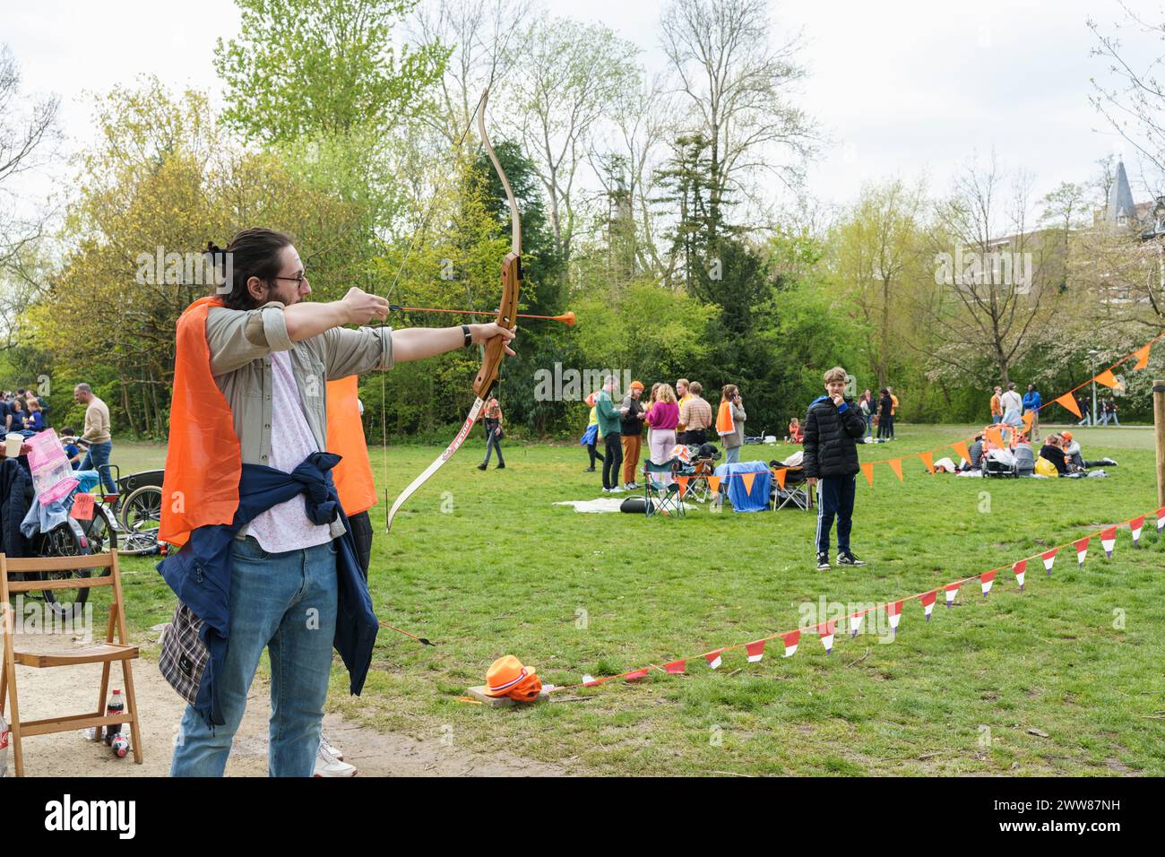 Un uomo ama il tiro con l'arco al King's Day nei Paesi Bassi. È una vacanza felice con il mercato delle pulci - Paesi Bassi, Amsterdam, 27.04.2023 Foto Stock