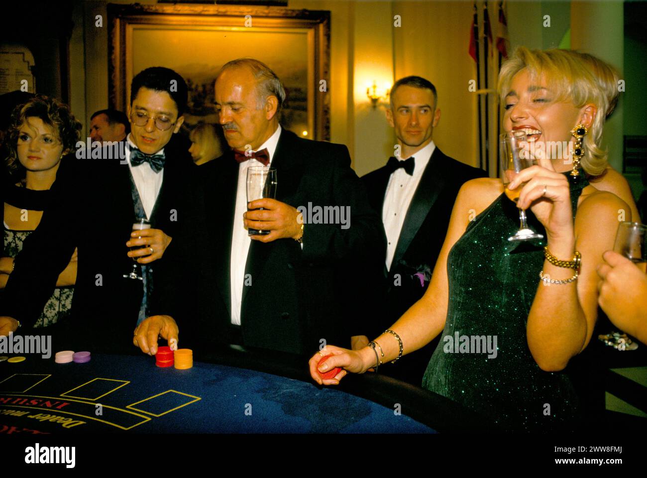 Ricchi inglesi che giocano a blackjack a festa privata di Natale. Giovane donna che fa ridere. Berkshire, Inghilterra circa 1995 dicembre Regno Unito 1990s HOMER SYKES Foto Stock