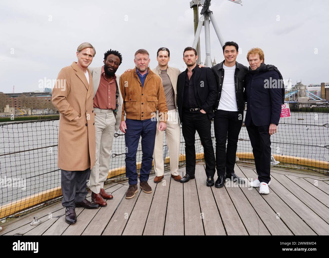 (Da sinistra a destra) Cary Elwes, Babs Olusanmokun, Guy Ritchie, Henry Cavill, Alex Pettyfer, Henry Golding e Jerry Bruckheimer partecipano a una chiamata fotografica per il Ministero della Guerra Ungentlemanly alla HMS Belfast, a Londra. Data foto: Venerdì 22 marzo 2024. Foto Stock