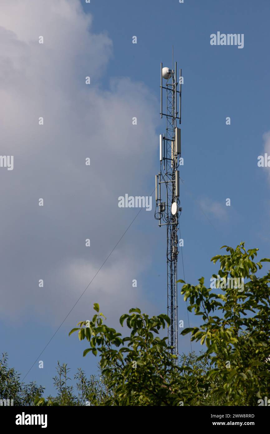 Torre della televisione, torre del telefono cellulare sopra la campagna sullo sfondo del cielo con nuvole Foto Stock